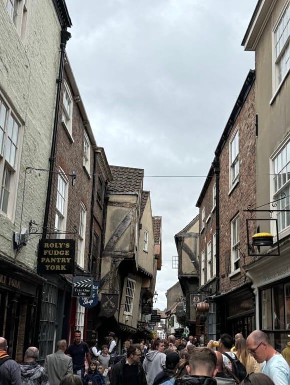 várias pessoas caminhando pela york shambles
