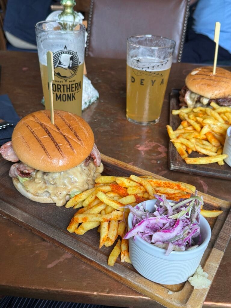 dois hambúrgueres e cerveja sobre a mesa
