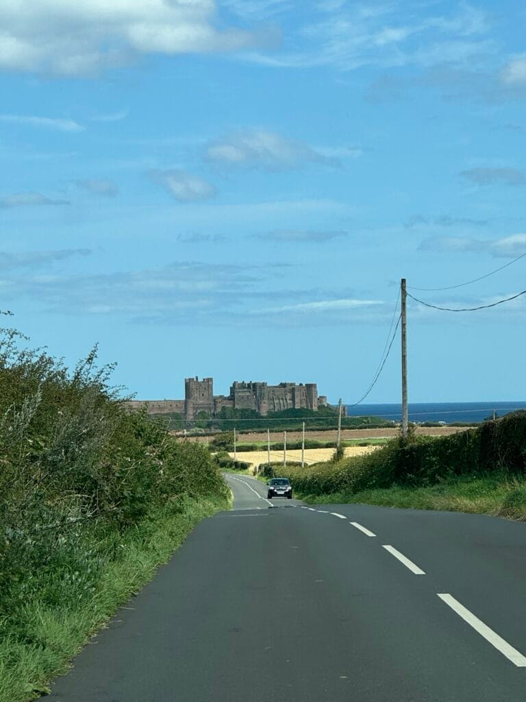 estrada com bela vista do castelo de bamburgh ao fundo