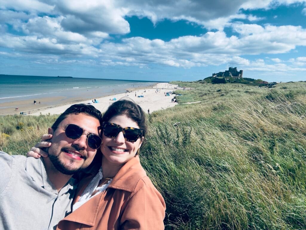 eu e meu marido na praia com o castelo de bamburgh ao fundo
